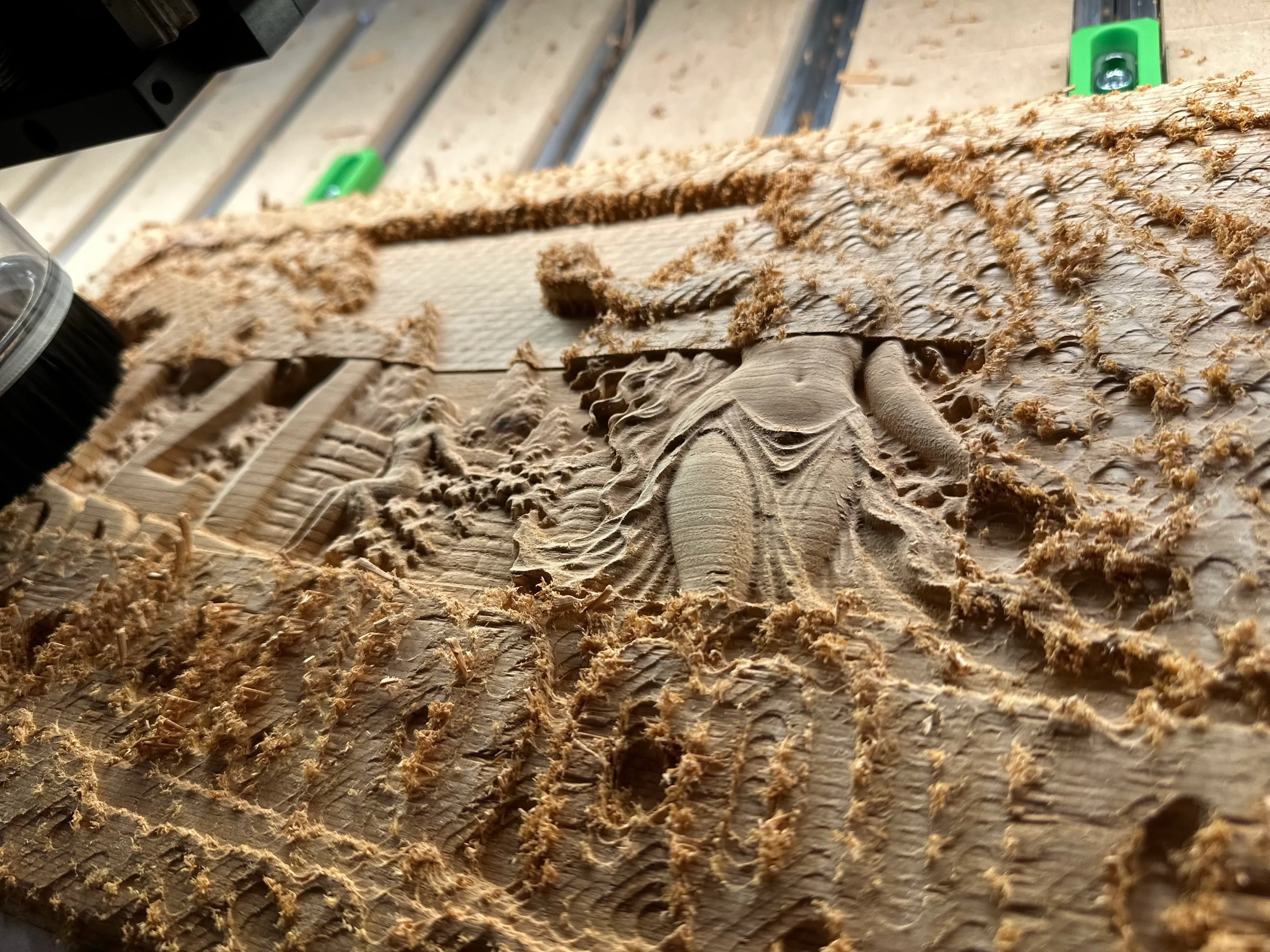 Close-up of a carved figure emerging during the finishing pass
