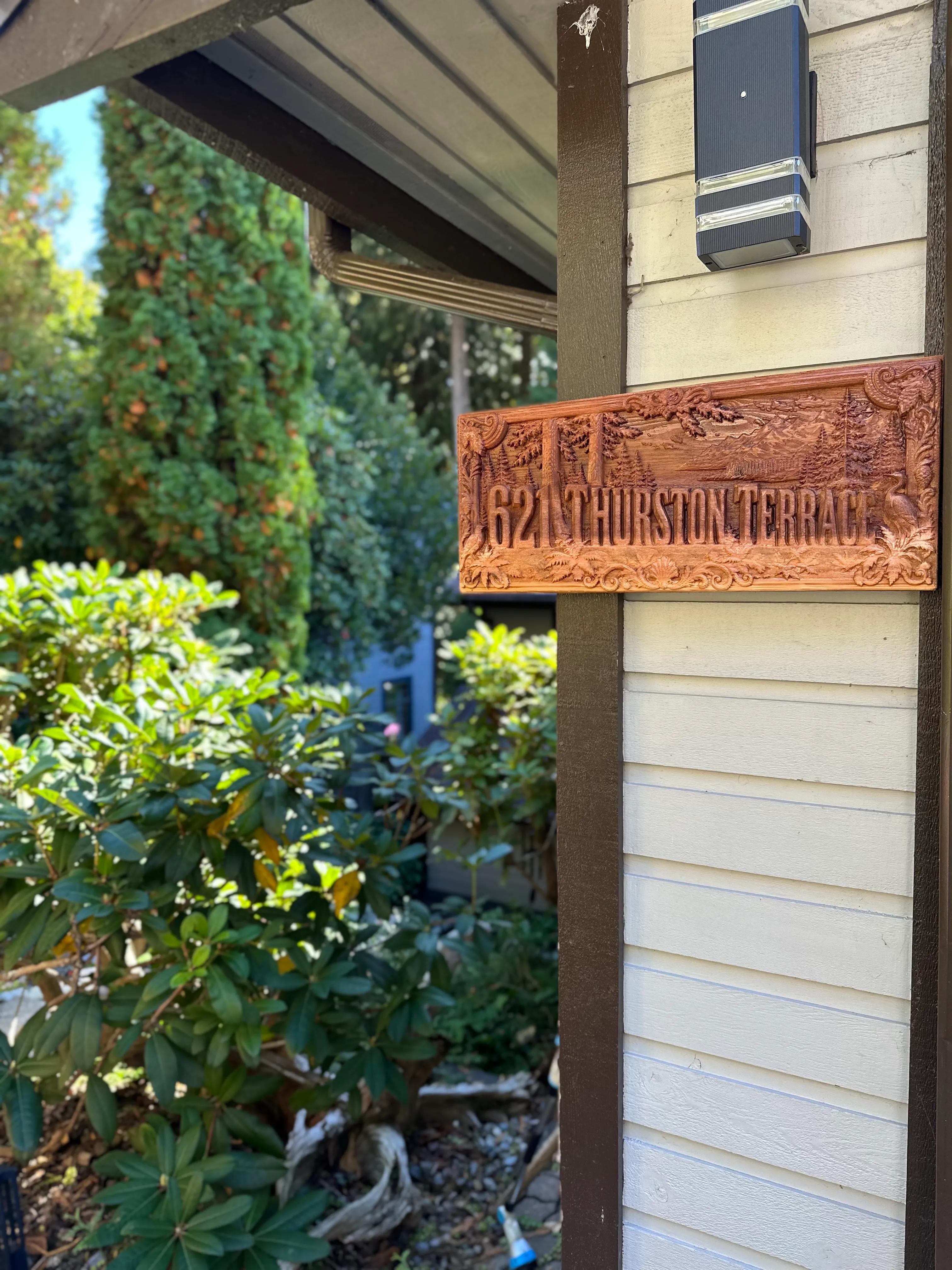 The 621 Thurston Terrace sign installed on the post of a house beside an outdoor light